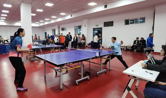 A group of people playing ping pongDescription automatically generated